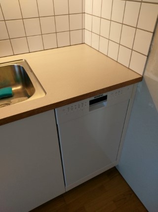 Diskmaskin, kakel och bänkskiva i nyrenoverat kök